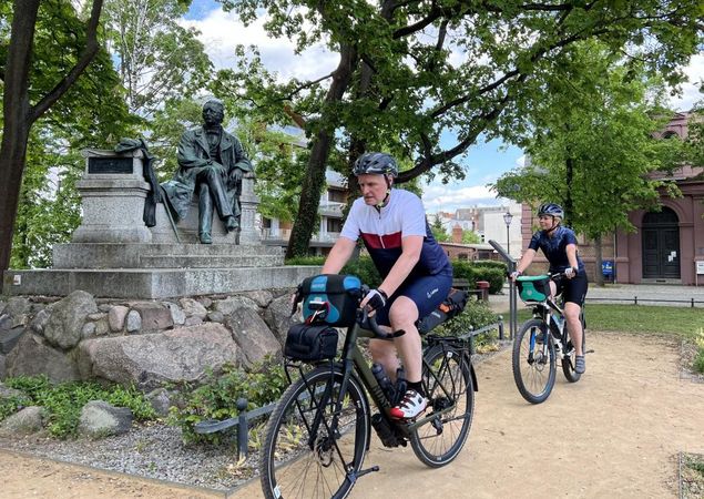 Radler vorm Fontane-Denkmal in Neuruppin, Foto: Thomas Widerin, Lizenz: Tourismusverband Ruppiner Seenland