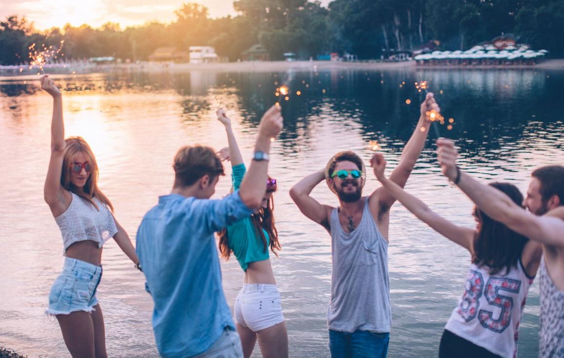 Menschen beim Feiern an einem See